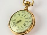 a gold pocket watch with roman numerals on it