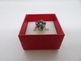 une bague dans une boîte rouge posée sur une surface blanche