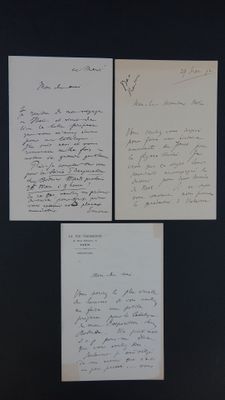 trois lettres manuscrites sur un morceau de papier posé sur une surface noire