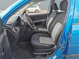 the interior of a small blue car with black seats and a steering wheel