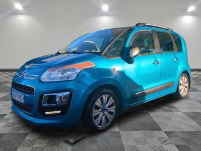 Une Citroën bleue est garée sur un sol carrelé à damier