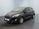 une voiture noire garée dans une pièce aux murs blancs