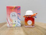 un petit flacon de parfum posé sur une table à côté d'une boîte