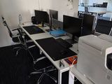 two computers and a printer on the desk in this office