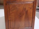 a small wooden cabinet on a table in a room