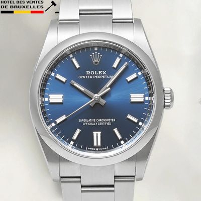 a close up of a watch with a blue dial on a bracelet