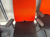 two orange and black office chairs sitting next to each other in a room