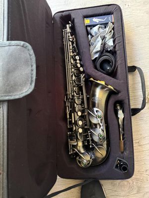 un saxophone dans son étui, posé sur un plancher en bois