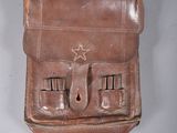 a brown leather bag with three compartments on it