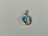 a small blue topaz stone pendant with a gold bail
