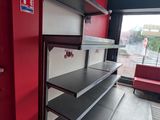 a red wall with shelves and a red couch in the corner