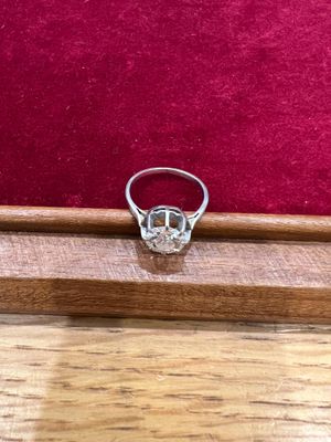 un gros plan d'une bague en diamant posée sur une table en bois