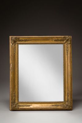 a gold framed mirror on a grey background