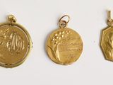 trois médailles d'or sont représentées sur un fond blanc