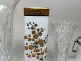 a glass vase with a gold lid and a vase with a flower design on it