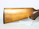 a close up of a wooden rifle on a clear stand
