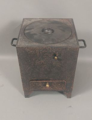 a small metal pot on a stand with a lid