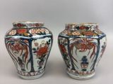 pair of chinese vases with floral designs on them sitting on a table