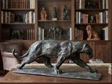 a statue of a cat on a table in a library