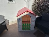 a small dog house with a red roof on the patio