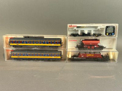 Deux petits trains sont exposés dans une vitrine posée sur une table