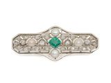 a close up of a brooch with pearls and emeralds