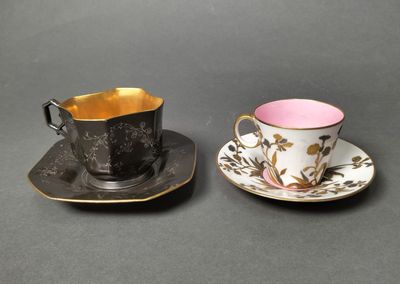 two cups and saucers are sitting on a table