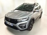 Un SUV argenté est garé dans une pièce blanche