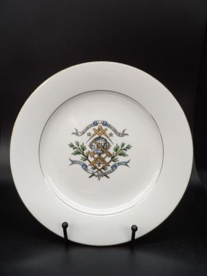 une assiette blanche ornée d'un motif doré et bleu