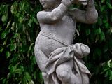a statue of a child holding a basket on top of a pedestal