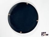 a black plate on a white wall with a black background