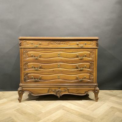 an antique chest of drawers on a chevroned wooden floor