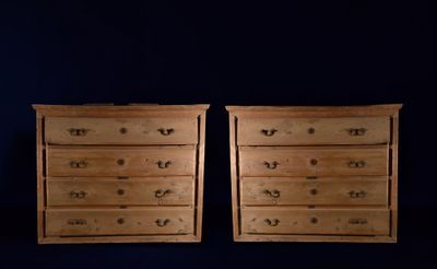 pair of wooden chest of drawers against a dark blue background