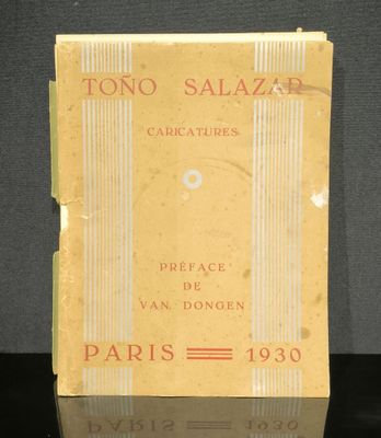un vieux livre à la couverture jaune posé sur une table noire