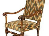 un fauteuil rembourré dont le dossier et les accoudoirs sont recouverts d'un tissu à motifs