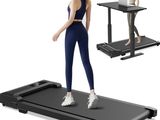 the woman is standing on a treadmill while using her laptop