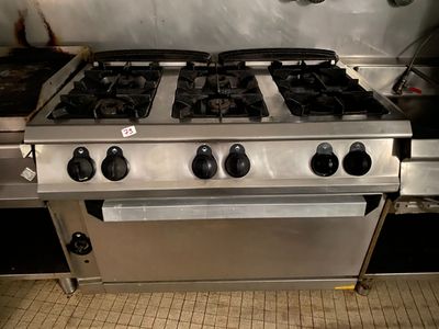 une cuisinière argentée équipée de quatre feux et de deux fours