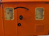 a small orange machine with a face drawn on it