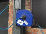 a blue hose attached to the side of a brick building