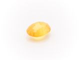 a yellow sapphire stone on a white background