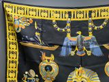 a black and yellow scarf with egyptian designs on it