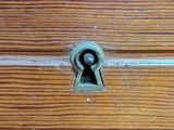 a wooden drawer with a keyhole on it