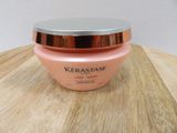 a close up of a jar of kerastasee cream on a wooden table
