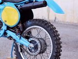 a blue dirt bike parked on the side of the road