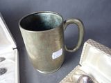 a silver cup with a spoon in it next to a box with a spoon