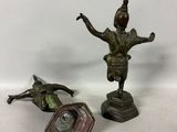 two bronze figurines of a man and a woman on a pedestal