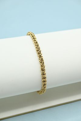 a gold chain bracelet on top of a white napkin