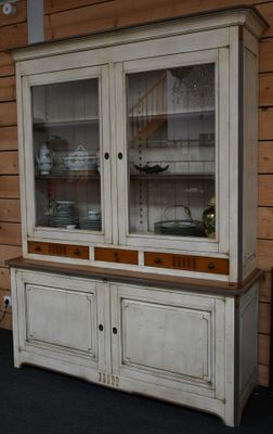 un vaisselier blanc aux portes vitrées dans une pièce