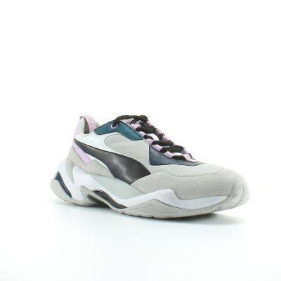 Les baskets Puma sont blanches et noires, avec des touches de violet.