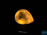 a close up of a yellow diamond on a black surface